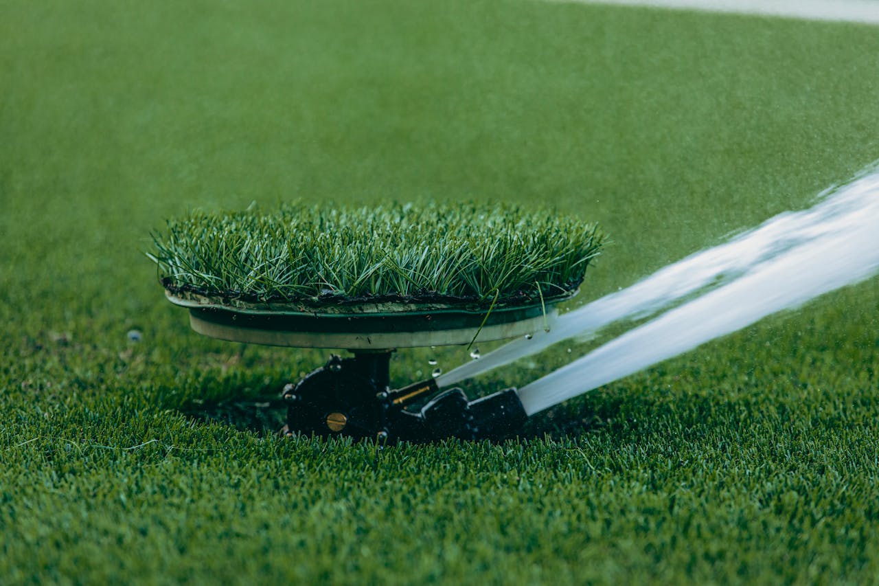 about-01 A close-up of an automated lawn sprinkler in action, showcasing efficient water usage on lush grass.